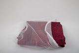 A Laundry Washing Bag partially covers a folded red fabric with black patterns, all set against a plain white background.