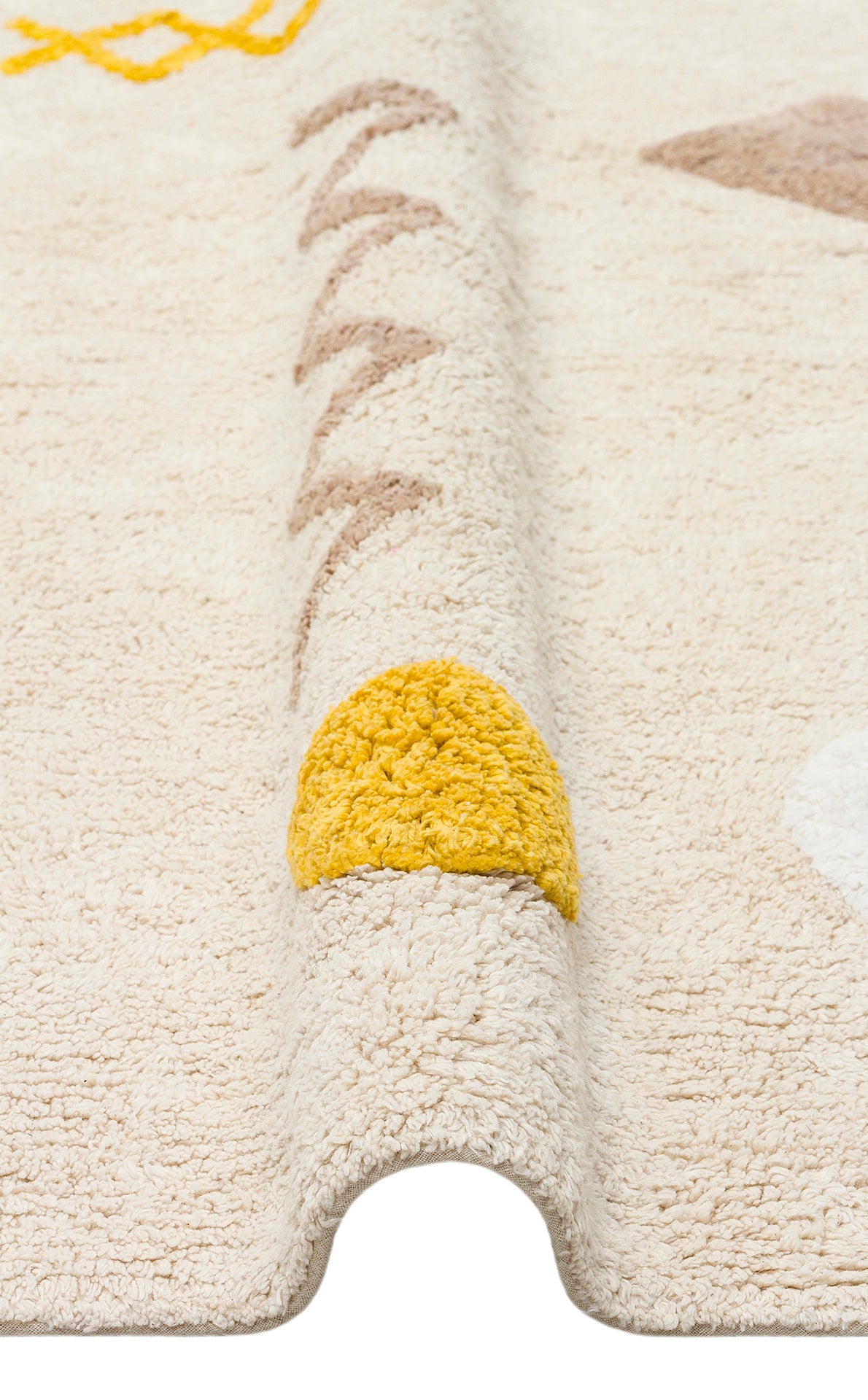 A close-up of the Little Dream - Washable Shaggy - CBN12 cotton rug, showing its folded edge and simple yellow, beige, and white geometric designs. The prominent yellow semicircle makes it ideal as a cozy kids’ room rug.