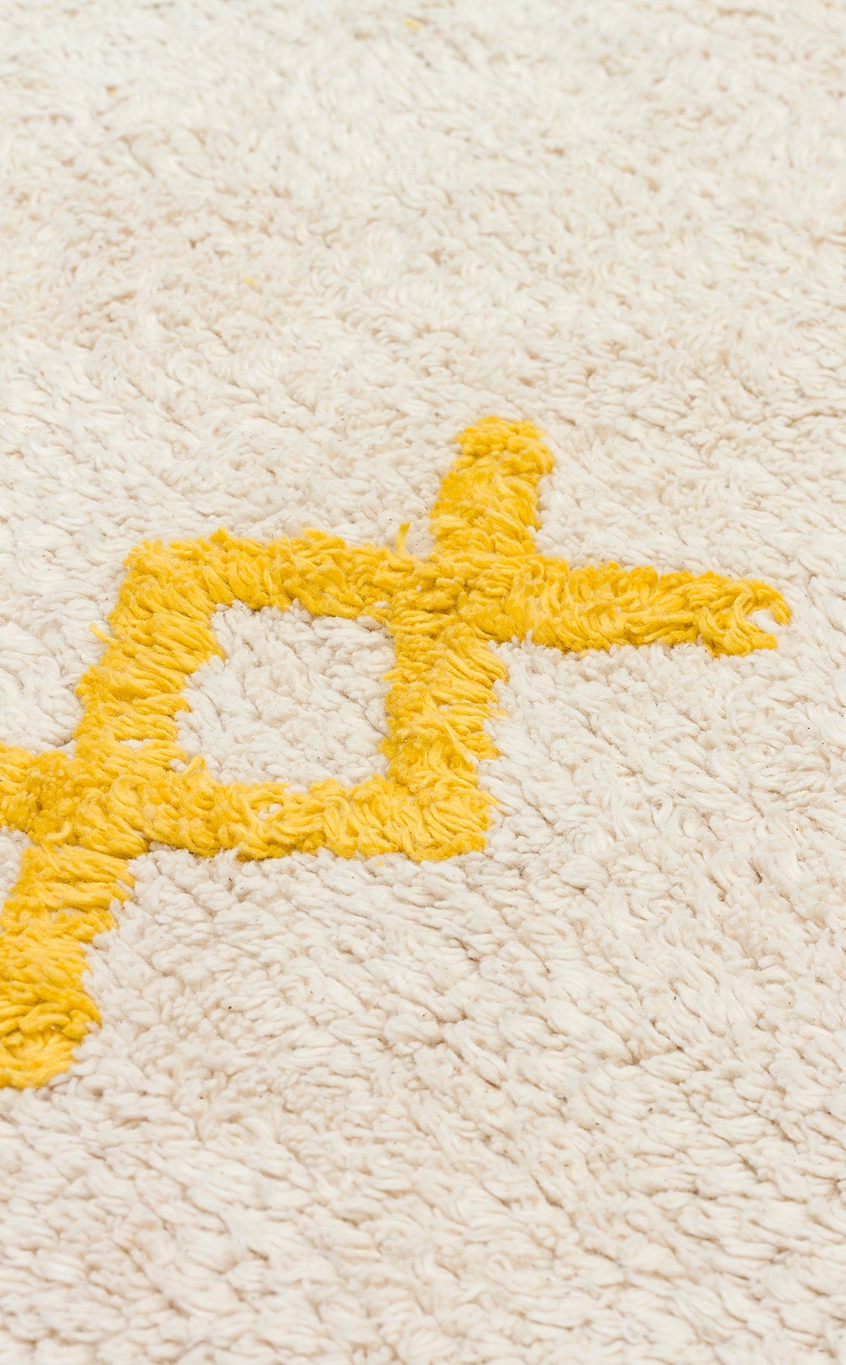 A close-up of the Little Dream - Washable Shaggy - CBN12: a plush cream cotton rug with a yellow geometric pattern, featuring a soft textured surface perfect for creating an inviting kids’ room.