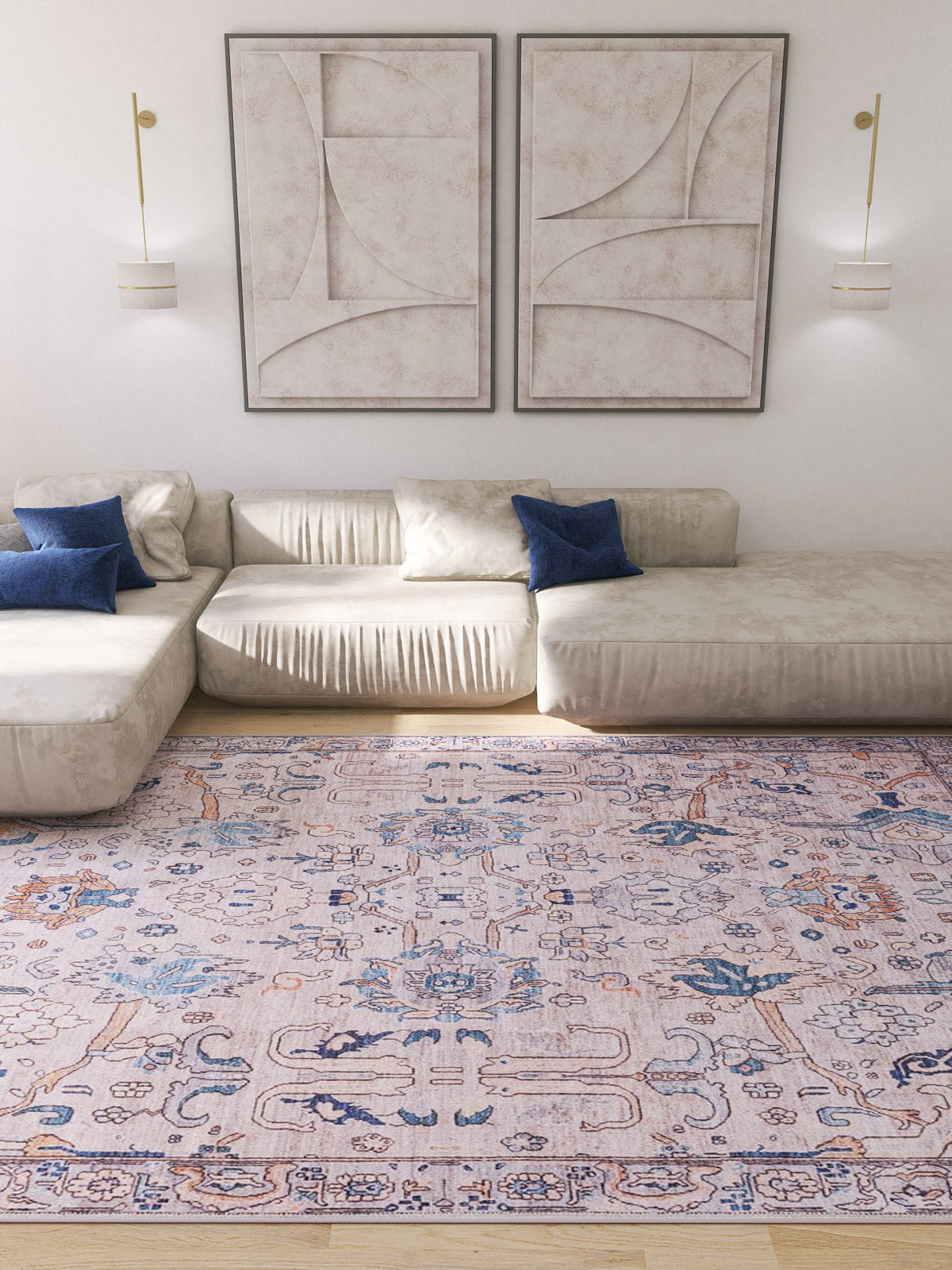 A modern living room with two beige sectional sofas, blue accent pillows, the Luminary Beige Gray Washable Rug - LCC3023 featuring blue and pink tones, two abstract wall art pieces, and minimalistic wall sconces.