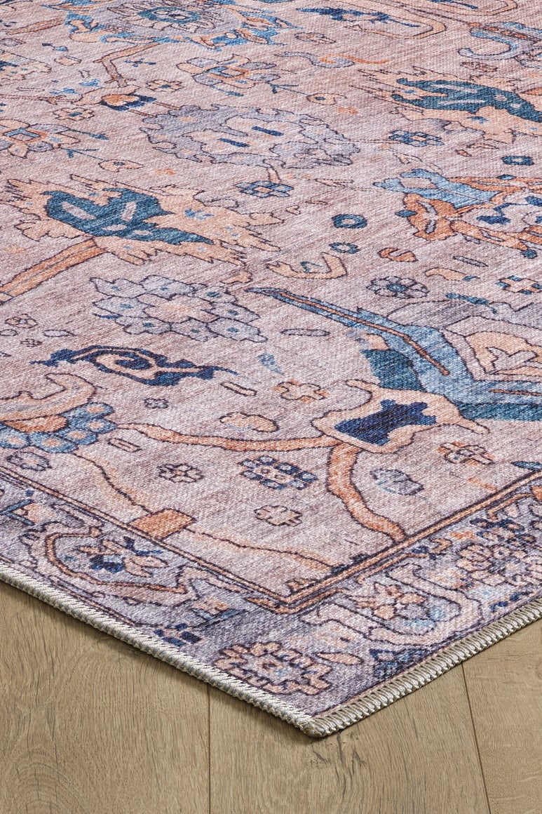 Close-up of the Luminary Beige Gray Washable Rug (LCC3023), showcasing its intricate floral and geometric patterns in muted pink, blue, and beige tones on a light wood floor.