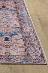 A close-up of the Luminary Beige Gray Washable Rug - LCC3023 (Custom Size) shows its blue, peach, and beige tones and stitched border on a light wooden floor, making it stylish and ideal for high-traffic areas.