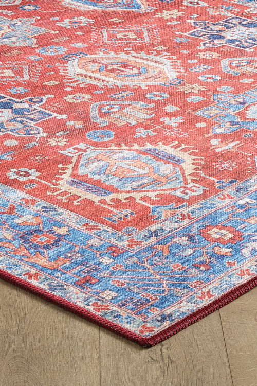 Load image 1 in gallery view. The Lunavale Red Blue Washable Rug (LCC3007) is displayed on a light wood floor, featuring intricate blue, white, and beige geometric patterns with a decorative border—ideal for high-traffic areas.