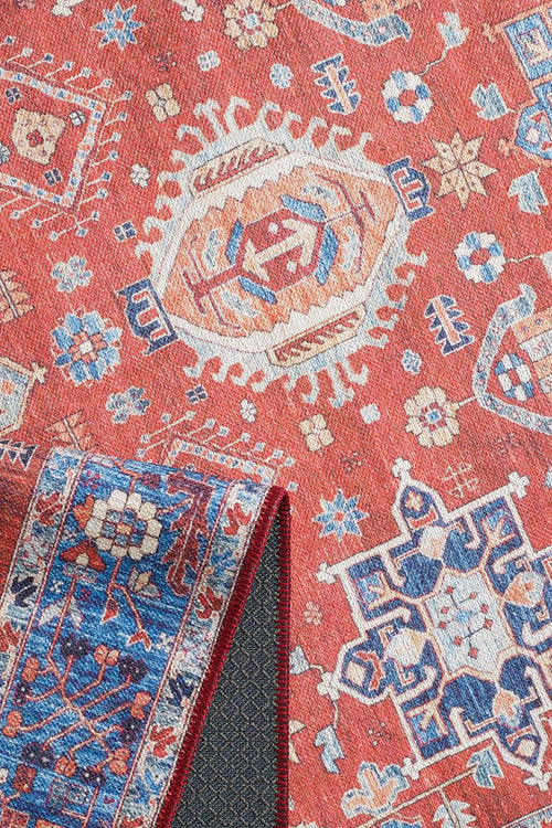 Load image 1 in gallery view. The Lunavale Red Blue Washable Rug - LCC3007 (Custom Size) features red, blue, cream, and gold geometric and floral patterns. Its flipped corner reveals a blue underside with matching motifs and textured backing—ideal for high-traffic areas.