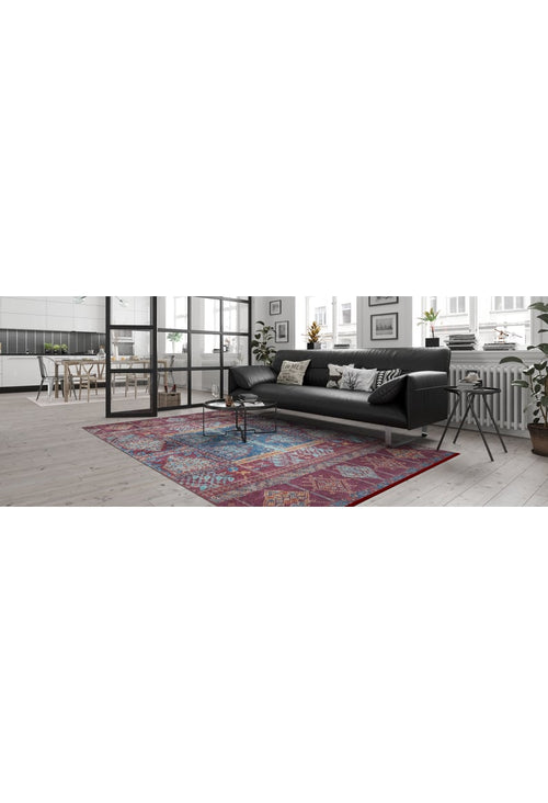 Load image 1 in gallery view. A modern living room with a black sofa, decorative pillows, small round coffee table, and the Majestic Mandarin - Washable Rug - JR1863 (Custom Size) on light wood floors. Large windows brighten the space and the kitchen area is visible in the background.