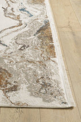 A close-up of the Majestic Marble Premium Area Rug - M673M, a modern machine-made rug with an abstract marble pattern in beige, brown, gray, and blue on a light wooden floor, featuring acrylic-viscose blend and a stylish white fringe edge.