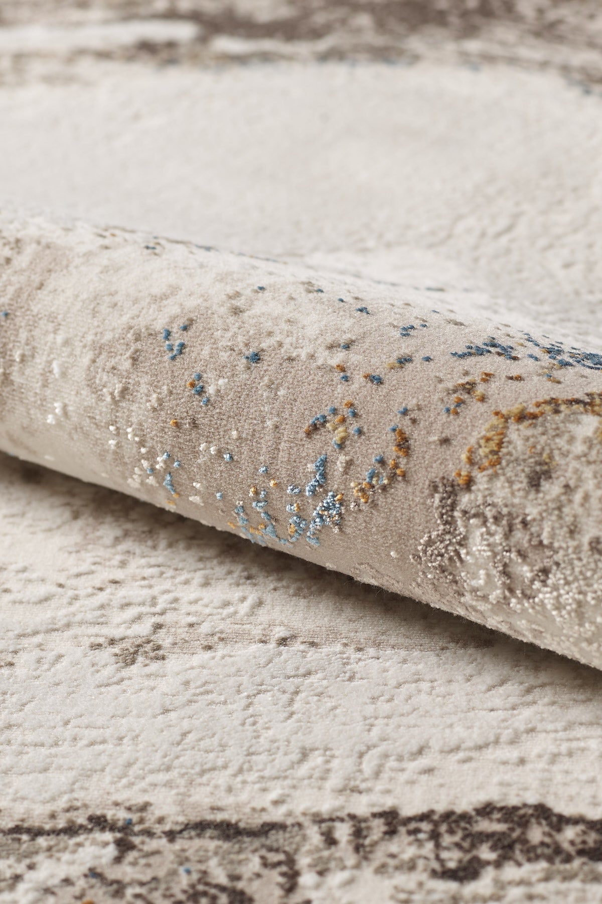 A close-up of the Majestic Marble Premium Area Rug - M673M, featuring a plush acrylic-viscose blend with a cream base and abstract blue, gold, and brown patterns. The textured pile and soft fibers are clearly visible.