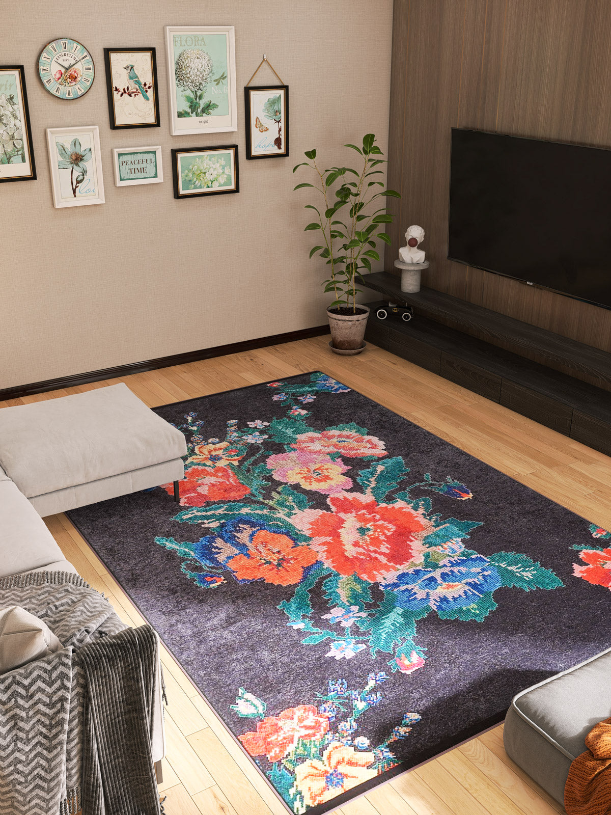 A modern living room with light wood floors, a Meadow Dream - Washable Rug - JR2001 in black ideal for high-traffic areas, a sectional sofa, a potted plant, a wall-mounted TV, and framed botanical art prints on the walls.