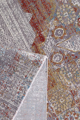 A close-up of the Medallion Remix Colorful Premium Rug - MT120 shows vibrant abstract patterns in red, yellow, blue, and gray, with one corner folded over to display the underside.