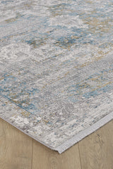 A close-up of the Medallion Revamp Modernised Medallion Rug - MT002, featuring a distressed abstract pattern in gray, blue, and beige tones with short white fringe, shown on a light wood floor.