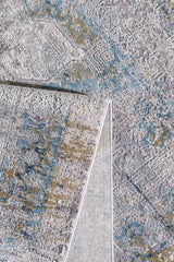 A close-up of the Medallion Revamp Modernised Medallion Rug - MT002 shows its textured surface and a folded corner, exposing blue, yellow, and gray abstract patterns on both sides.