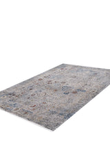The Miniature Elegance Oushak Rug - Grey - 2084F is a rectangular, machine-made rug featuring a faded vintage pattern in blue, gray, beige, and rust tones. Crafted from modal silk-polyester and shown on a white background.