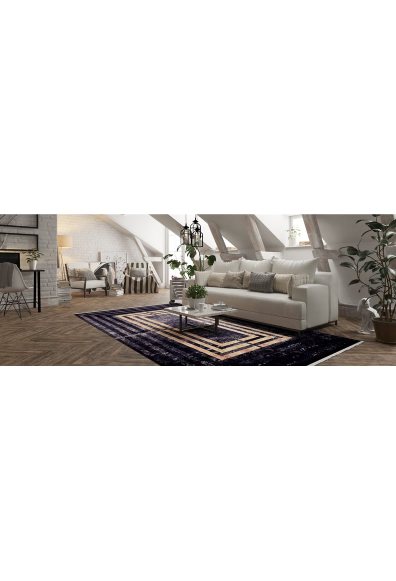A modern living room features a white sofa, neutral pillows, a glass coffee table, potted plants, and the Minimalist and Clean - Washable Rug - JR1407 (Outlet) US on wooden floors beneath slanted beams and large windows.