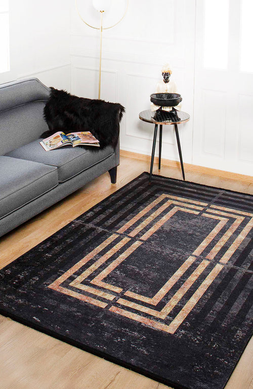 Load image 1 in gallery view. A modern living room with a gray sofa, black faux fur throw, and round side table sits on the Minimalist and Clean - Washable Rug - JR1407 (Custom Size), featuring geometric gold and beige patterns—ideal for high-traffic areas on light wood flooring.