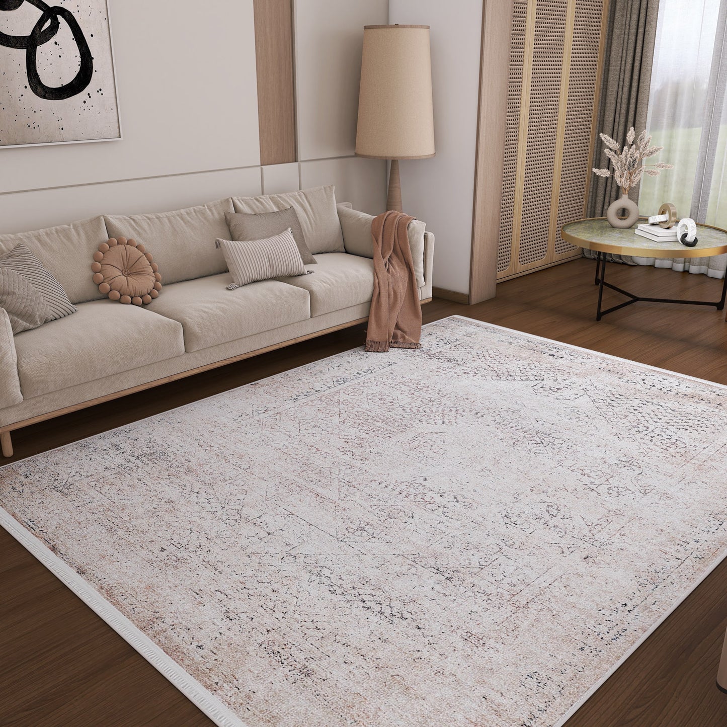 A cozy living room features a beige sofa, floor lamp, round side table, and neutral pillows. The Misty Mosaic - Washable Rug - JR1690 (Custom Size) anchors the wooden floor, while soft lighting creates a calm atmosphere.