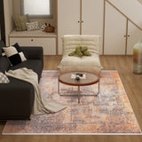 A modern living room with a black sofa, round coffee table, and the Modern Mosaic - Machine-Washable Rug JR1846, ideal for high-traffic areas. Decorative pillows, a throw, large vase, and pumpkin accent add flair to light wood floors and built-in cabinetry.