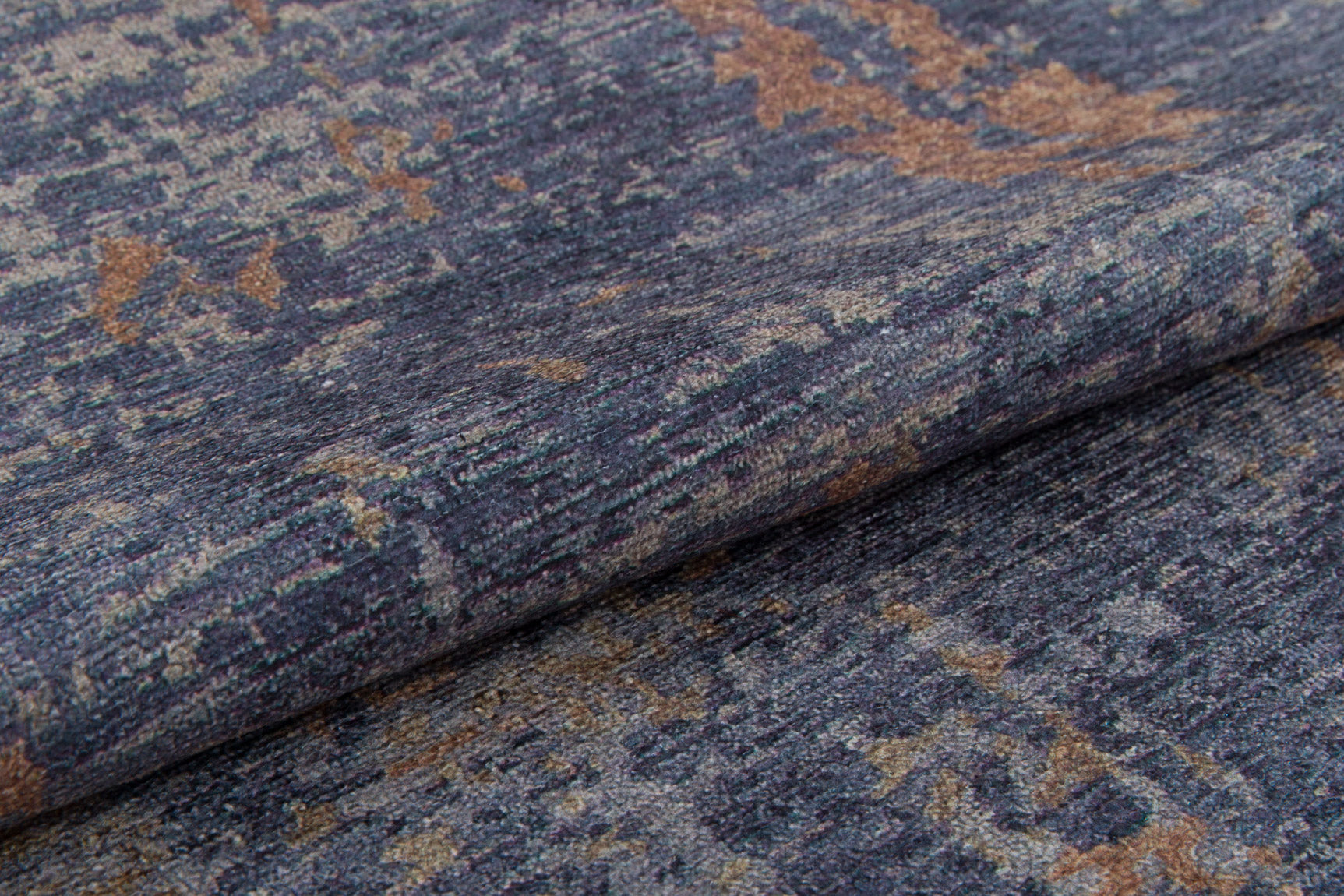 Close-up of the Mystical Mosaic - Washable Rug - JRS003 (Outlet) US, featuring a folded, textured surface and mottled blue, gray, and brown pattern—perfect for high-traffic areas and displaying the rug’s soft fabric detail.