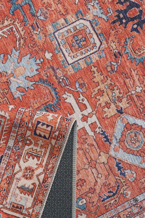Load image 1 in gallery view. A close-up of the Mystral Kilim-Design Coral Washable Rug - LCC3015 (Custom Size), showing vibrant geometric and floral patterns in red, blue, cream, and orange. A corner folds over to display its gray non-slip backing—perfect for high-traffic areas.