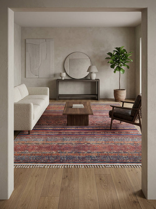 Load image 1 in gallery view. A modern living room with a white sofa, dark armchair, wooden coffee table, and the Native Nightscape - Washable Rug - JR5093. The space includes a potted plant, round mirror, minimalist wall art, a console table, and neutral-toned walls and floor.