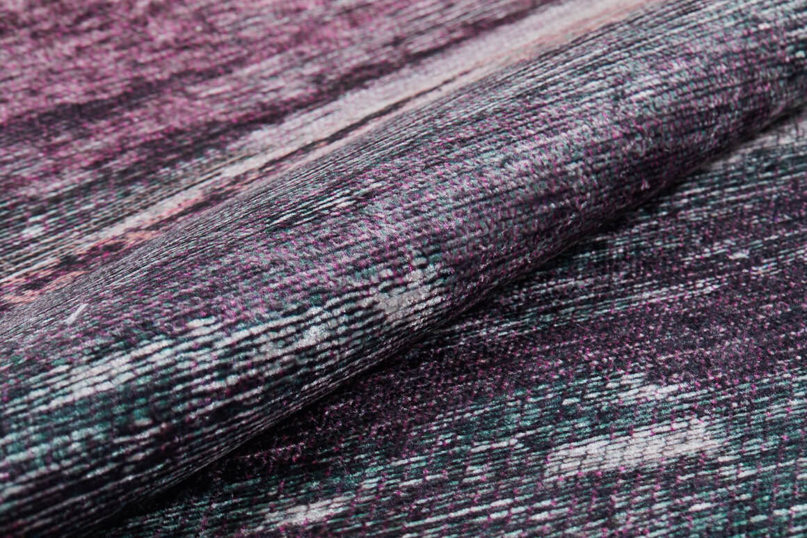 Close-up of the Natural Brushed - Washable Rug - JR336 (Custom Size), showcasing its folded, textured purple surface with pink, black, and white woven patterns—slightly rough and abstract, perfect for high-traffic areas.