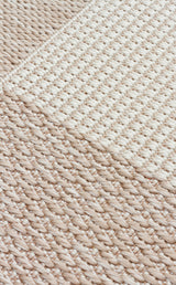 Close-up of the Natural Stitch - Kilim - MNO01 rug, featuring thick, interlaced fibers in a beige and off-white diagonal and square textured pattern for a soft, minimal look.
