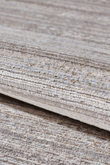 A close-up of the Neutral Frame Modern Bordered Rug - EW5541 shows its soft, slightly shiny surface and rolled, textured design with striped beige, gray, and cream tones.