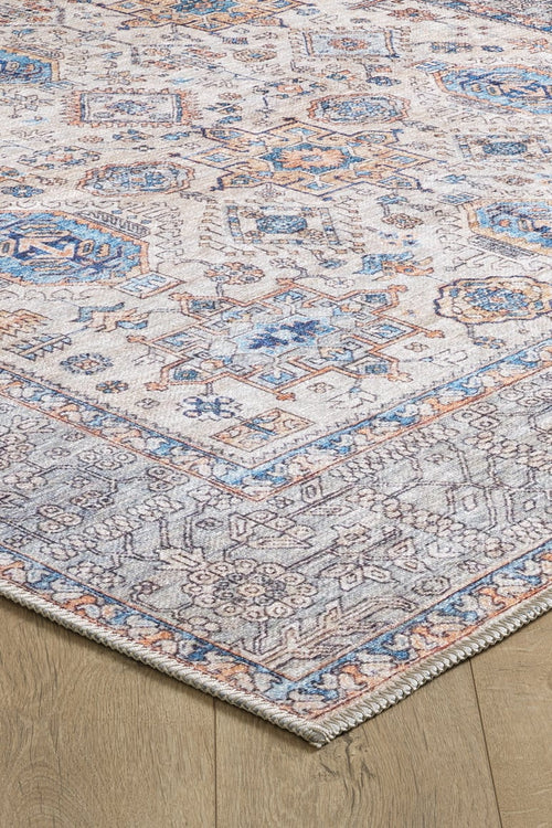 Bild 1 in Galerieansicht laden. A close-up of the Nexa Bordered Beige Washable Rug - LCC3009 (Custom Size) shows its blue, beige, and rust geometric pattern with detailed borders on a light wood floor. This washable rug has a slightly faded vintage look, ideal for high-traffic areas.
