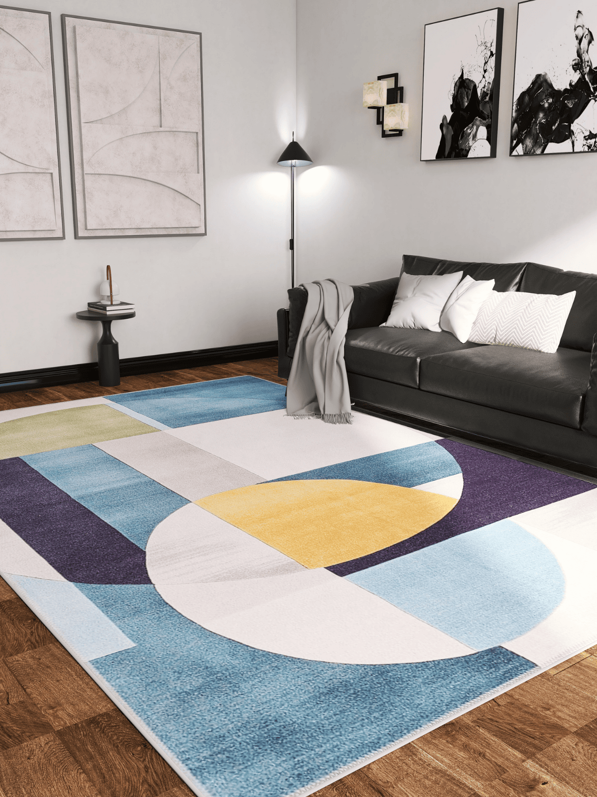 A modern living room features a dark sofa, white pillows, gray throw, abstract wall art, and the Nexus Geometric Contemporary Washable Rug - MDJ006 (Custom Size)—ideal for high-traffic areas—on wood floors, with a floor lamp and side table nearby.