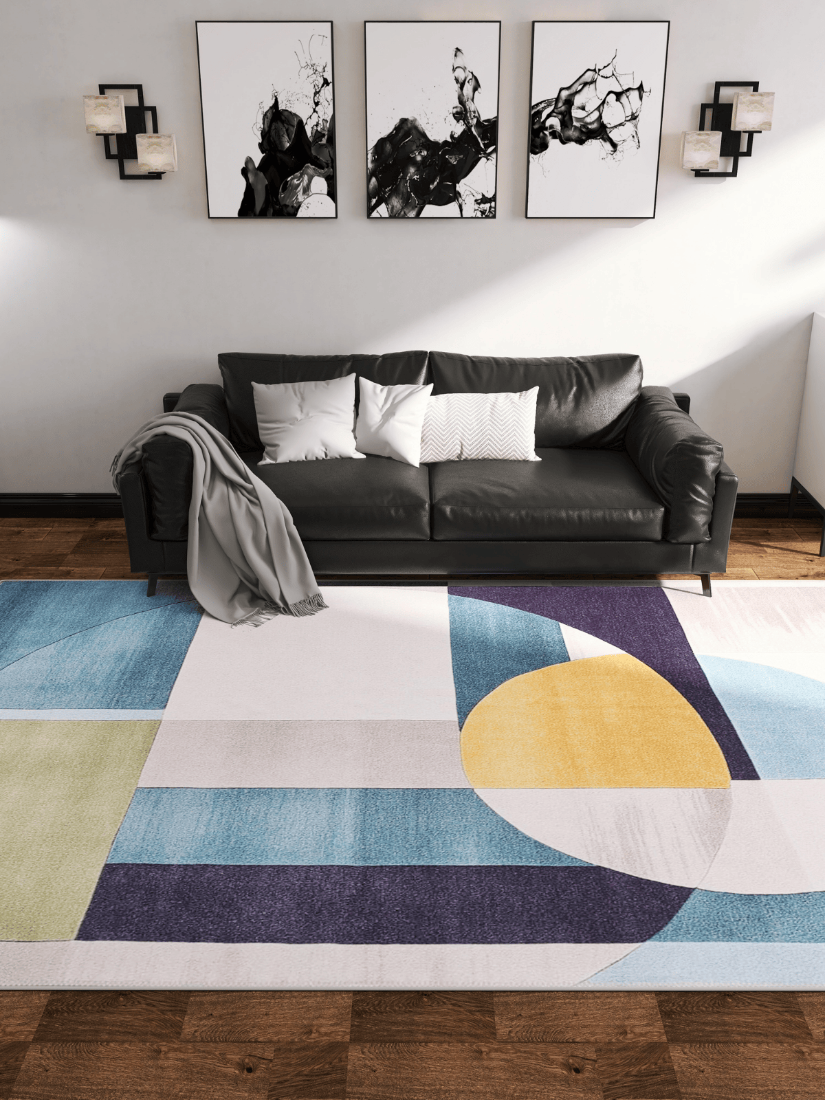 A modern living room features a black sofa, gray throw, abstract B&W art, and the Nexus Geometric Contemporary Washable Rug - MDJ006 (custom size) with blue, yellow, green, and purple shapes—perfect for high-traffic areas on wooden floors.