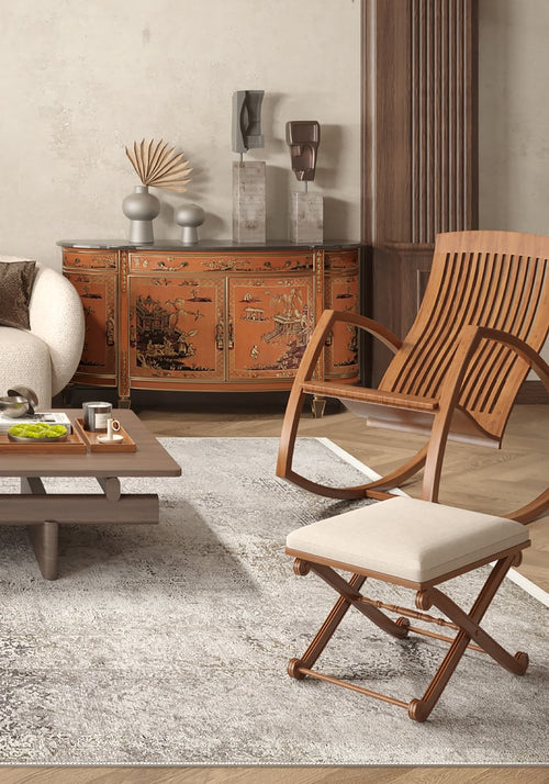Load image 1 in gallery view. A modern living room features a beige sofa, wooden coffee table with tea set, curved chair with white cushion, and ornate orange sideboard. The Noble Insignia - Washable Rug - JR1830 (Custom Size) adds warmth and suits high-traffic areas.