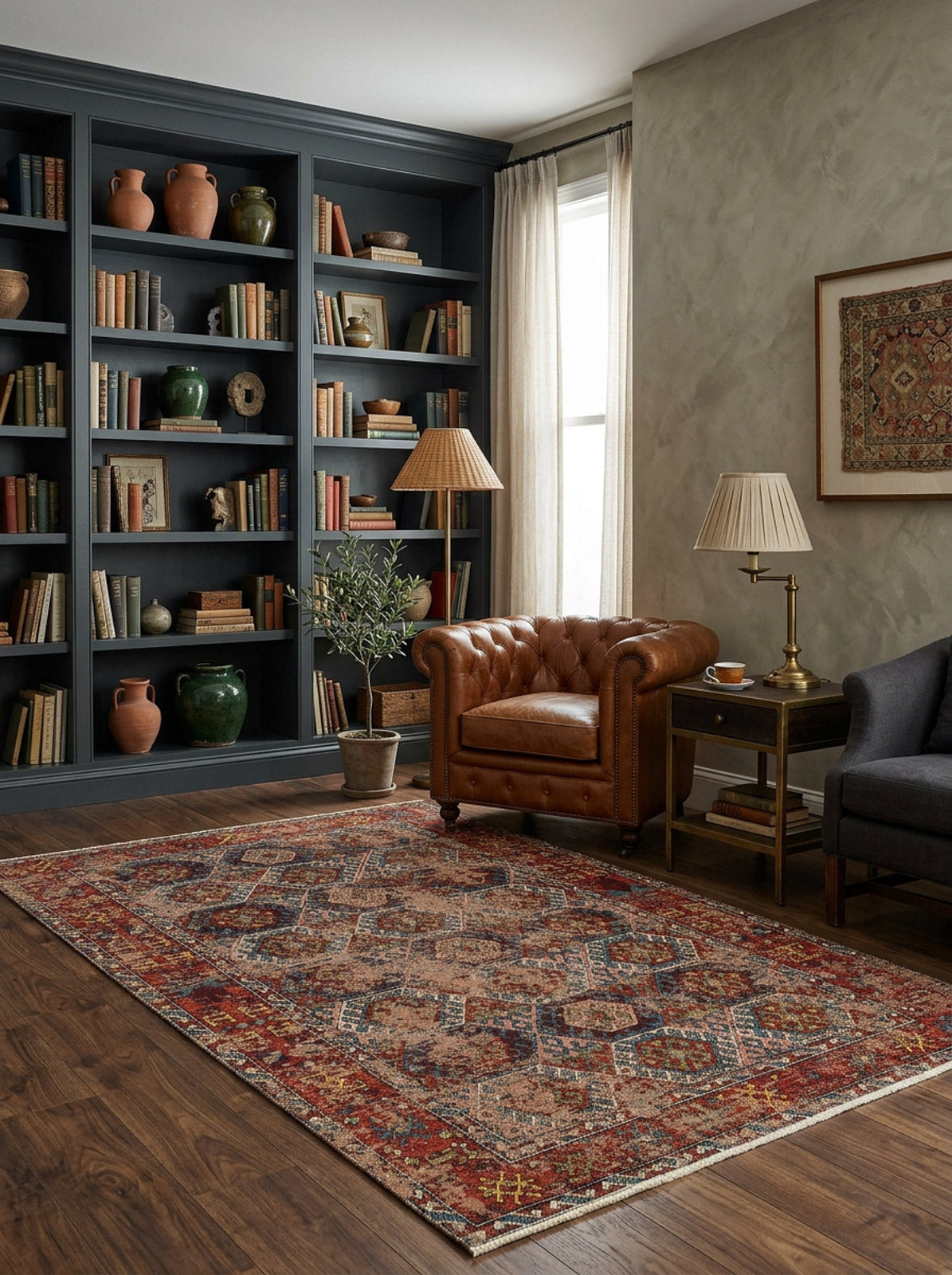 A cozy living room featuring a brown leather armchair, side table with lamp, bookshelf, and wooden floors is enhanced by the distressed aesthetic of the Nomad Spirit - Washable Kilims - AND03 under soft natural light through sheer curtains.