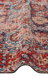 A close-up of the Nomad Spirit - Washable Kilims - AND03 shows its red, blue, and beige tribal patterns with a raised ripple, highlighting the intricate flatwoven texture and weave of this unique rug.