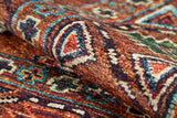 A close-up of the Nomadic Oasis - Washable Rug - JR5086 (Custom Size) reveals vibrant geometric patterns in red, orange, blue, green, and cream—showing detailed texture and ideal for allergy-sensitive or high-traffic areas.