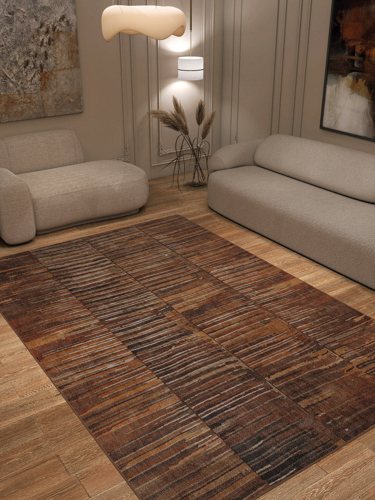 A modern living room with two beige sofas, a Nostalgic Weft - Washable Rug - JRN33 (Custom Size) in brown pattern for high-traffic areas, wooden floor, wall art, sculptural pendant light, and a decorative vase with dried grass.