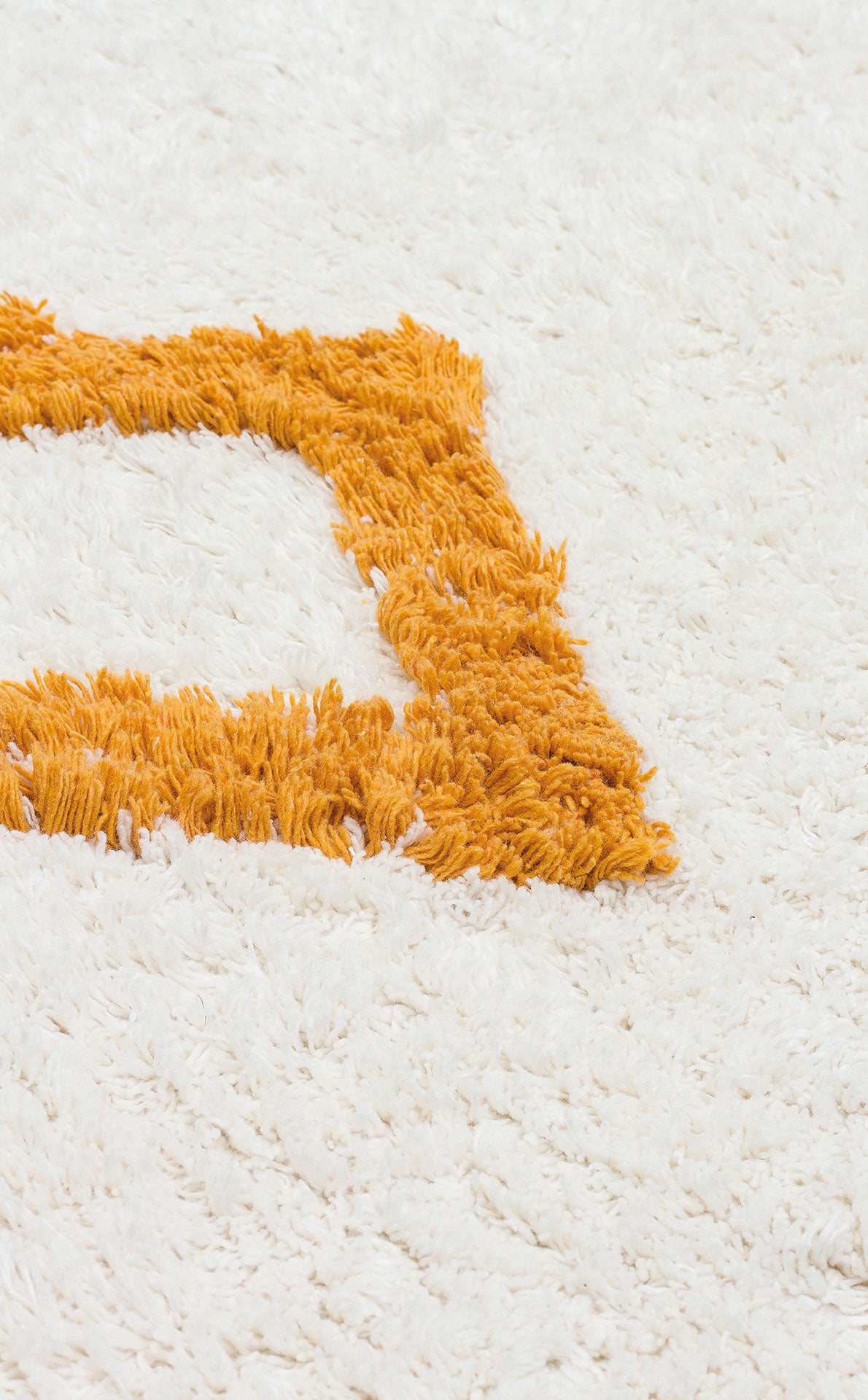 Close-up of the Nursery Nest - Washable Shaggy (CBN04), a plush cotton rug with an orange rectangular border, showcasing its soft texture—ideal as a cozy nursery rug.