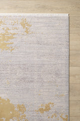 The Old World Elegance Modern Rug - Yellow - M677O, a machine-made viscose-polyester rug with a light grey, beige, and subtle gold abstract pattern plus fringe on the top edge, lies partially visible on a light wood floor.