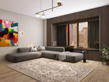 Modern living room with a large gray sectional sofa, abstract wall art, neutral pillows, city view through wide windows, and the Opulent Mirage - Washable Rug - JRN1008 (Custom Size). A small side table and potted plant complete the inviting space.