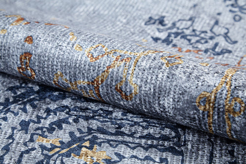 Load image 1 in gallery view. A close-up of the Oriental Treasures - Machine-Washable Rug JR1613 (Custom Size), featuring a rolled, textured gray flat weave with intricate abstract blue, yellow, and orange patterns that add depth and elegance to this durable rug.