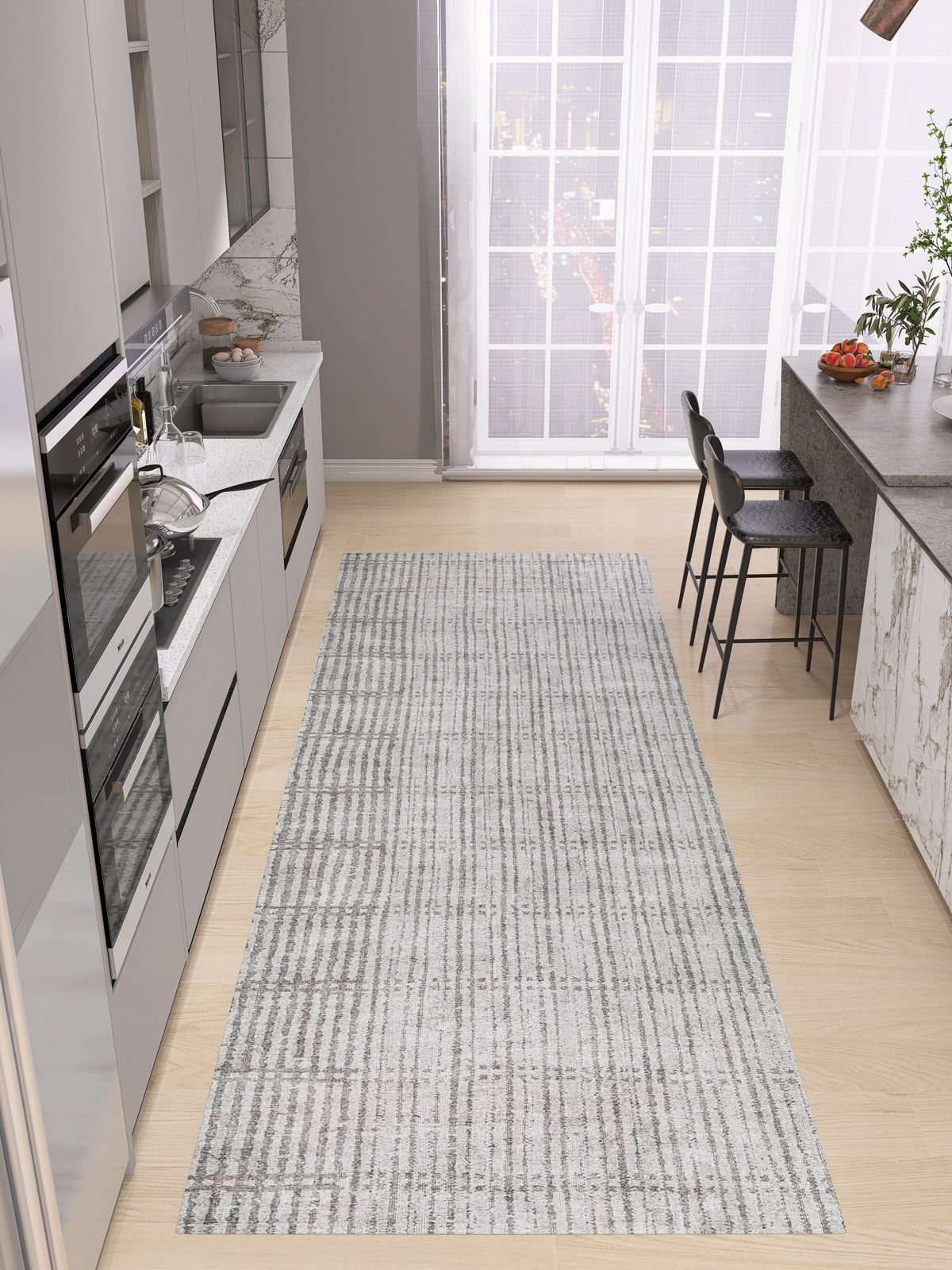 Modern kitchen with light wood floors, gray cabinets, built-in appliances, marble backsplash, and a custom-size Ornate Hues – Washable Rug (JRN38); breakfast bar with black stools and large windows—ideal for contemporary interiors.