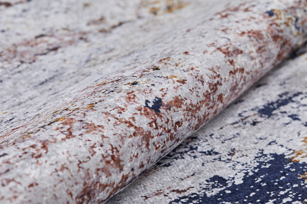 A close-up of the Painted Dreams - Washable Rug - JR432 (Custom Size), featuring a soft, textured abstract pattern in white, beige, brown, and dark blue. Its weathered look is ideal for high-traffic areas and it’s easy to clean.