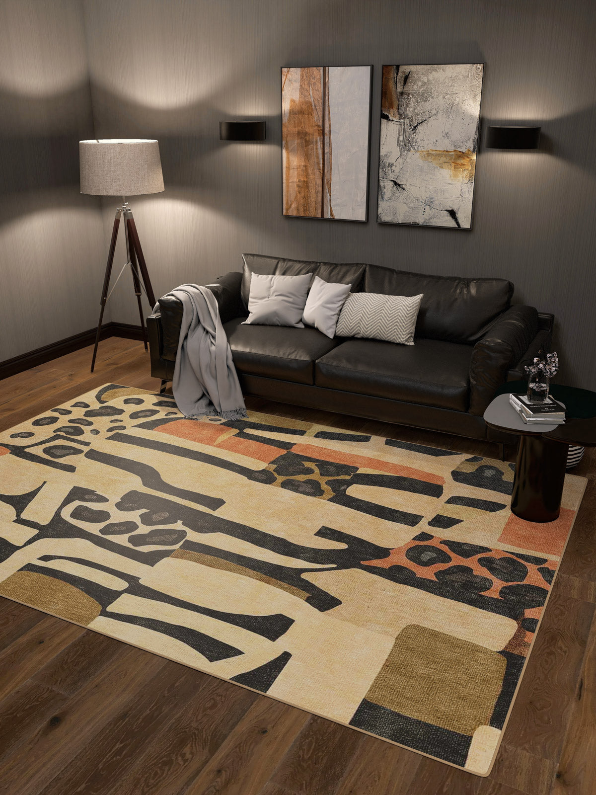 A modern living room featuring a black leather sofa, throw blanket, accent pillows, tripod floor lamp, two abstract wall artworks, the Pastel Harmony - Washable Rug - JRN43 with geometric patterns, and a small side table on wooden flooring.