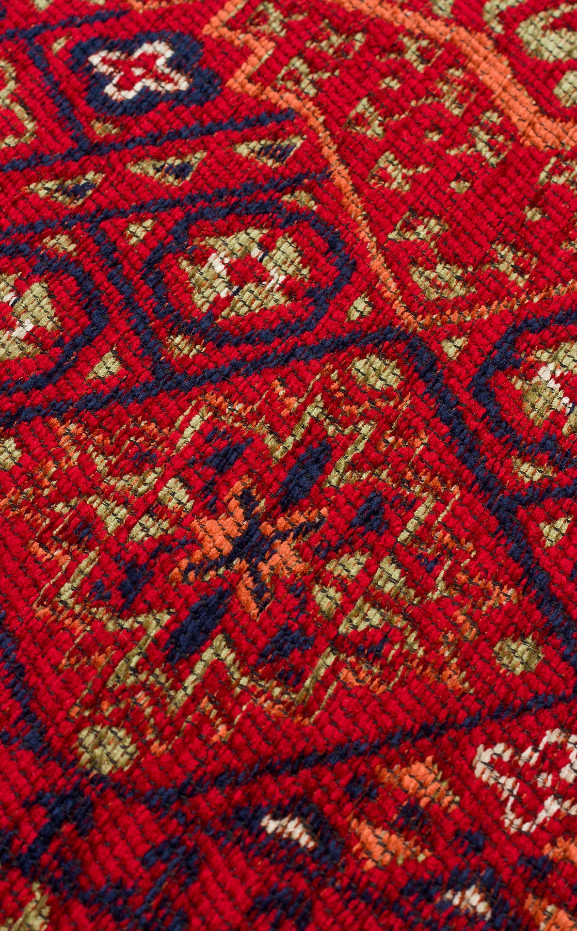 Close-up of the Patch Bloom - Kilim - BHR10 rug, showing intricate geometric and floral patterns in shades of red, navy blue, green, and orange with a clearly visible woven fiber texture.