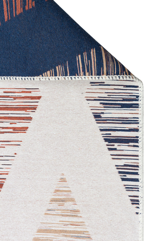 Load image 1 in gallery view. A close-up of Pattern Field - Washable Reversible Kilims - AR38 shows triangular orange and navy designs. The folded corner reveals a dark blue underside with a striped edge on this stylish, washable flatwoven rug.