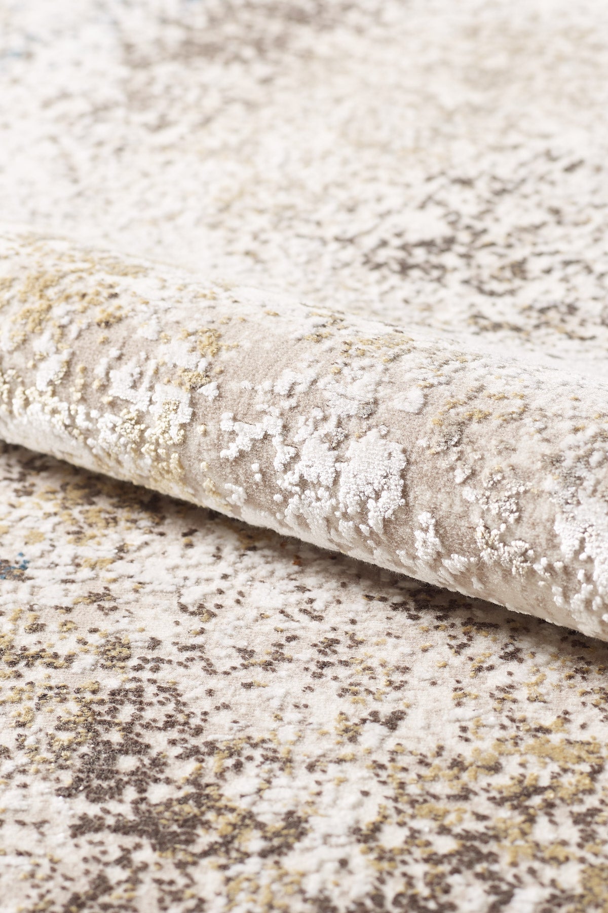 A close-up of the Pebble Pathway Premium Area Rug - M683L reveals a soft, plush surface with a textured abstract pattern in beige, cream, and subtle hints of brown and yellow. This machine-made rug combines style with comfort.