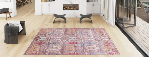 Bild 1 in Galerieansicht laden. A spacious modern living room with light wood floors, a Peregrine Peachy Brown Washable Rug, a black woven chair, two curved stools, a marble fireplace, and large glass doors leading outside.