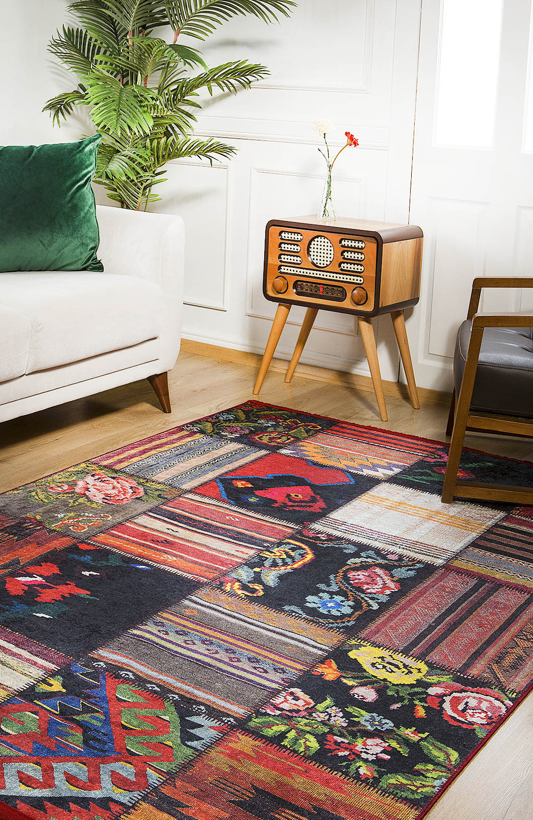 The Petal Paradise - Washable Rug - JR315 (Custom Size) with vibrant geometric and floral patterns brightens a wooden floor beside a white sofa, making it ideal for high-traffic spaces and adding a cozy touch to the room.