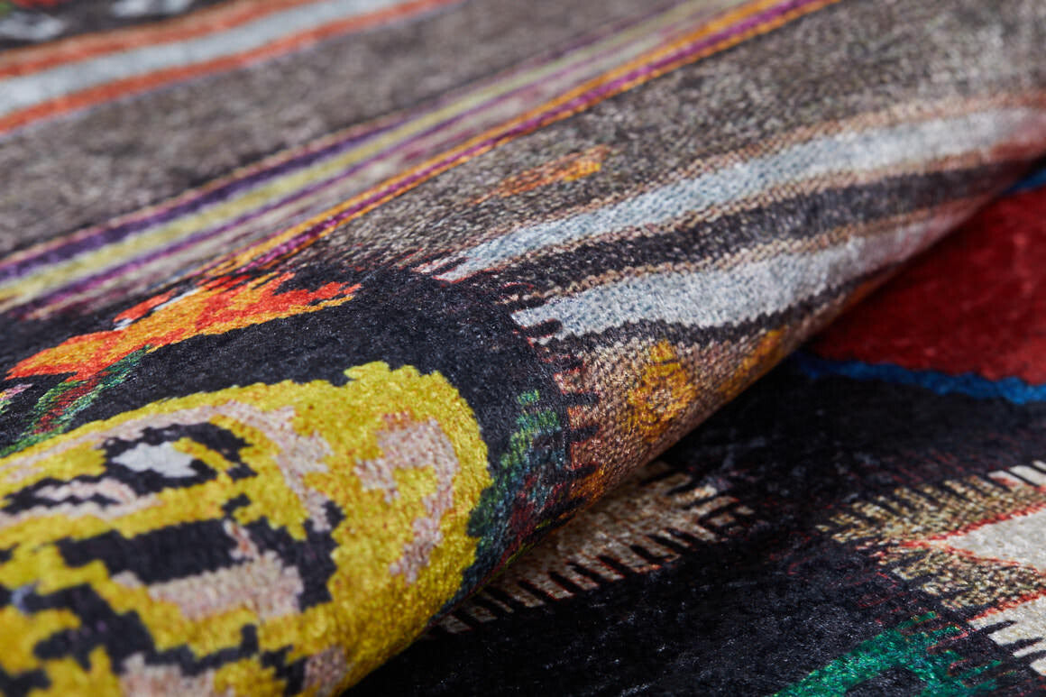 A close-up of the Petal Paradise - Washable Rug - JR315 (Custom Size) reveals vibrant multicolor patterns and rich yellow, black, red, and orange accents—durable and stylish for high-traffic areas, with texture shown by a gentle fold.