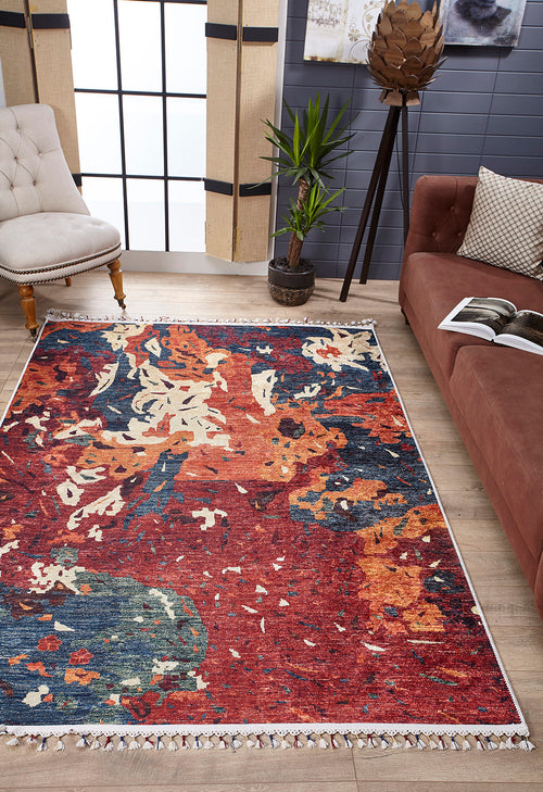 Load image 1 in gallery view. A modern living room with a Psychedelic Splash - Machine-Washable Rug (JR5096), abstract-patterned—ideal for allergy sufferers—brown sofa and pillow, cream tufted chair, potted plant, floor lamp, and large window with sheer curtains.