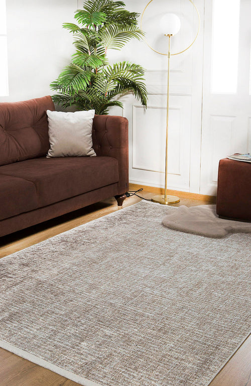Load image 1 in gallery view. A cozy living room featuring a brown sofa, white pillow, Pure Bliss - Washable Rug - JR745 (Custom Size) ideal for allergy-sensitive homes, potted plant, floor lamp with round shade, and ottoman on wooden floors by white walls and doors.