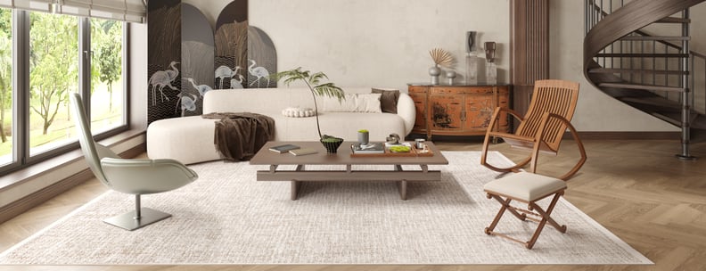 A modern living room with large windows, a white curved sofa, wooden chairs, a low coffee table, the Pure Bliss - Washable Rug - JR745 (Custom Size) for allergy-sensitive comfort, a spiral staircase, and crane-design screens.